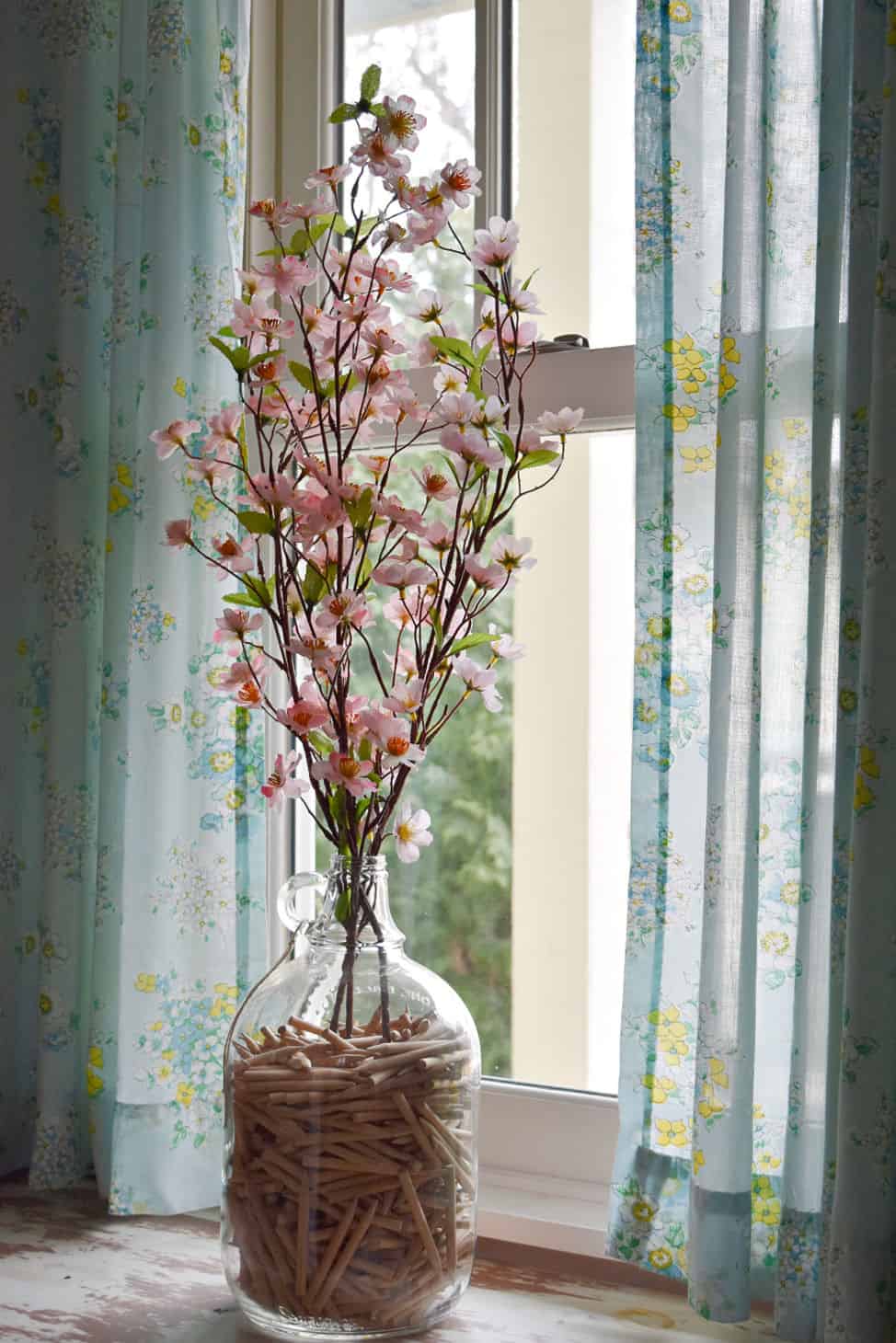 Flowering apple blossom branches in glass jug as Spring decor.
