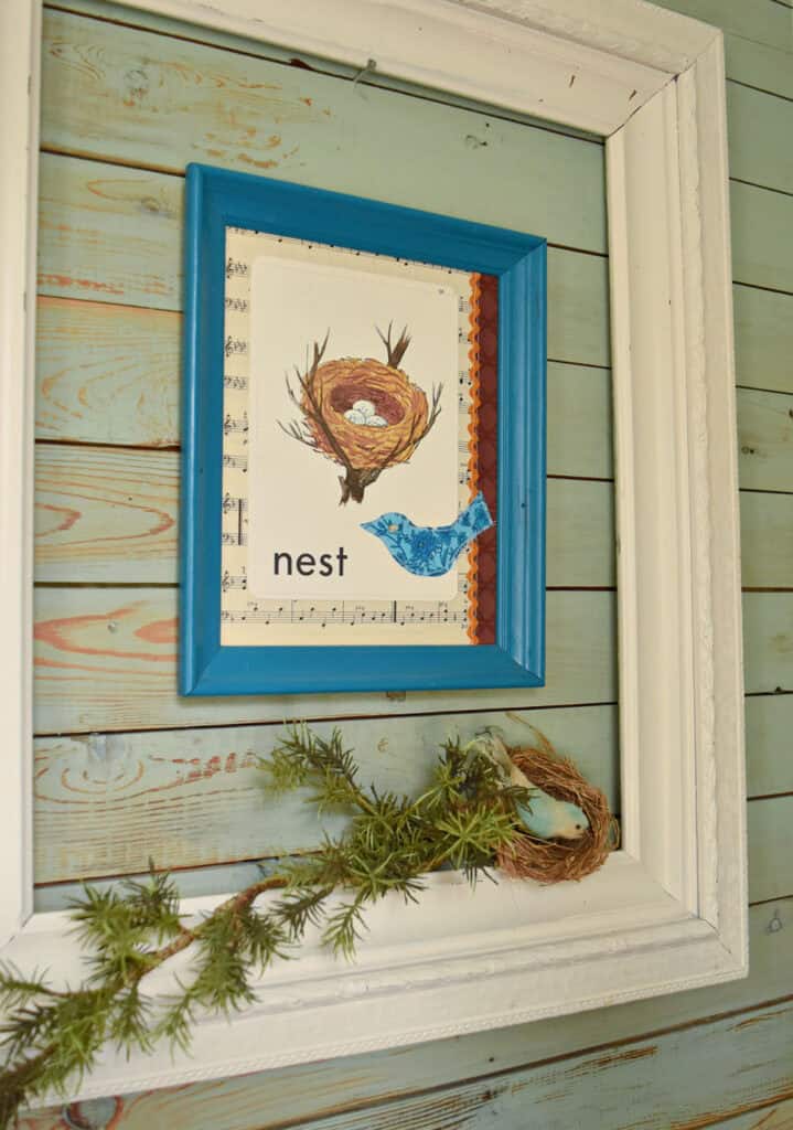 Green branch sitting on old frame with nest theme.