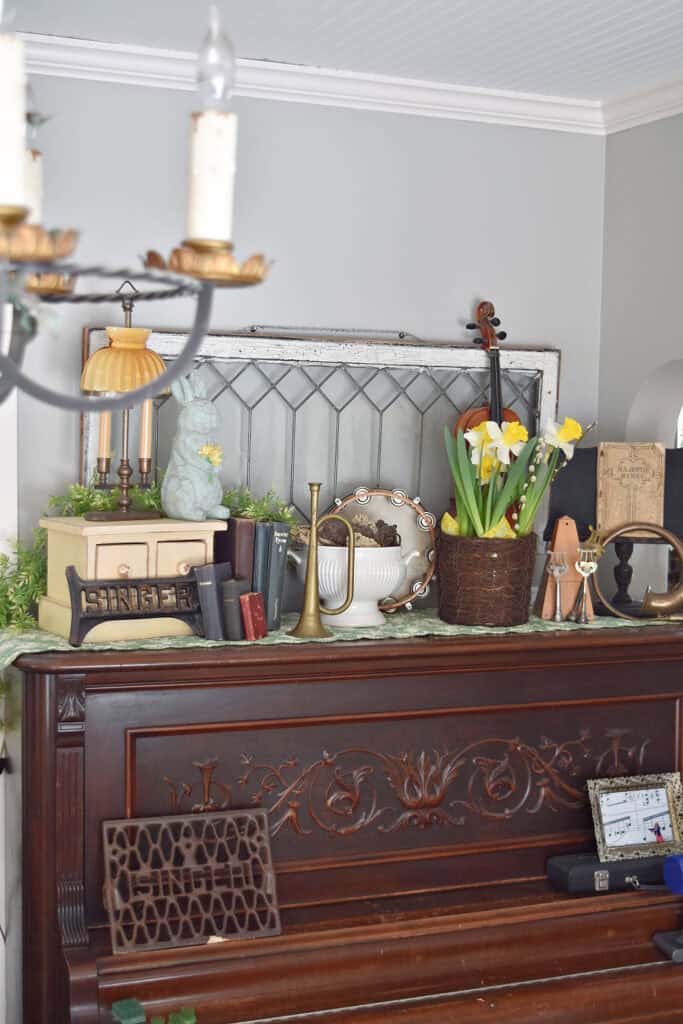 Antique piano with music themed vignette on top.