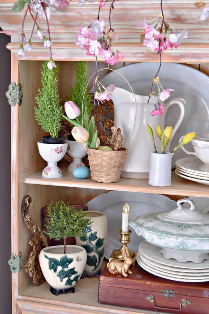 Spring decorated shelves with ironstone and topiaries.