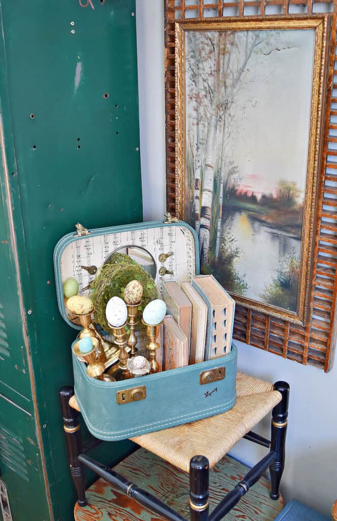 Suitcase vignette with old books, brass candlesticks and Spring eggs.