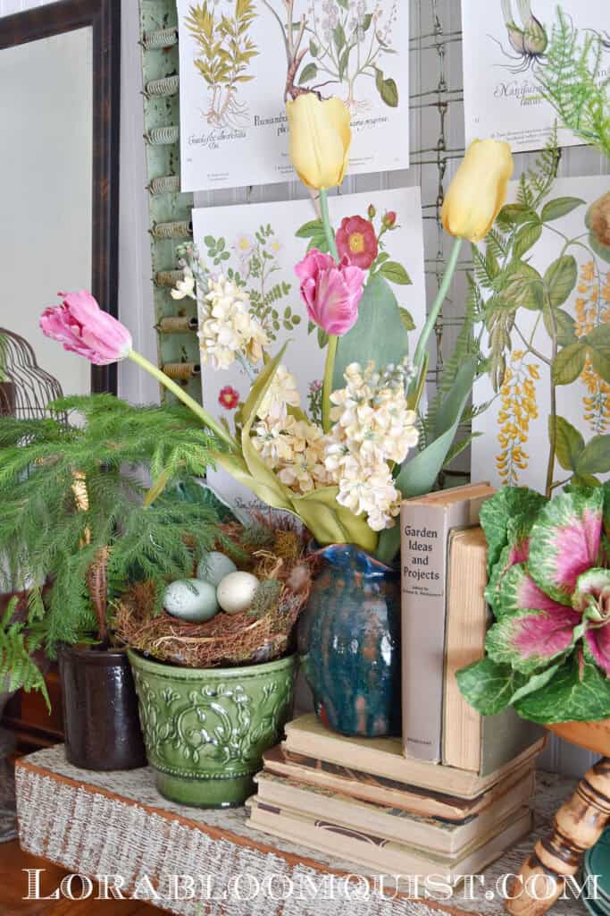 Spring flowers, nest with eggs and books on Spring mantel display.