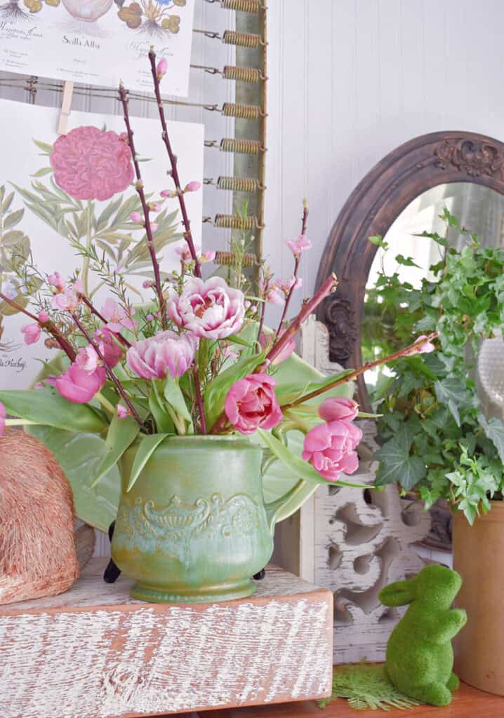 Green pottery pitcher with pink double tulips.