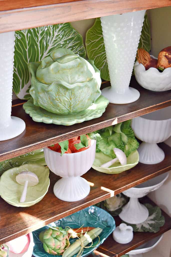 Vintage and new cabbage ware pieces on shelf display.