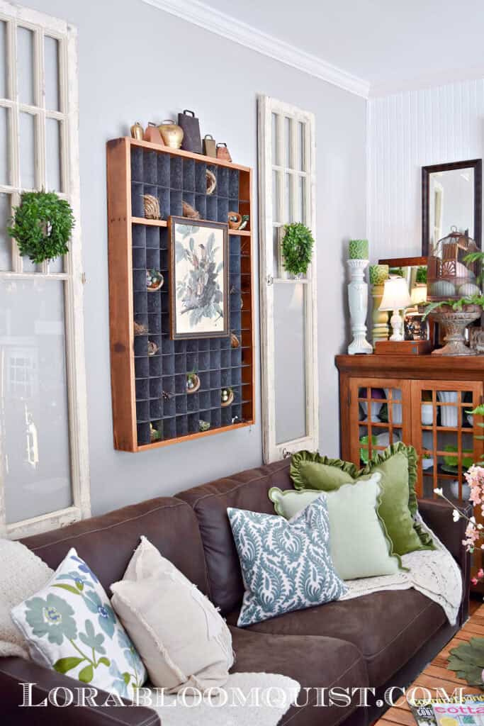 Brown sofa with Spring pillows and vintage salvaged pieces as wall art.