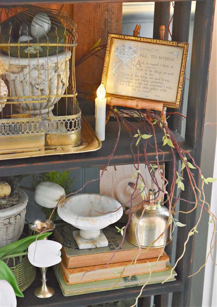 Vintage finds decorate a bookshelf for Spring.
