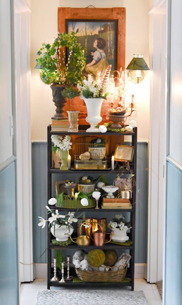 Bookshelf in hallway decorated with vintage finds for Spring.