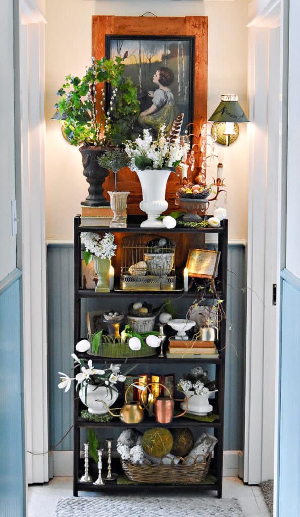 Bookshelf in hallway decorated with vintage finds for Spring.