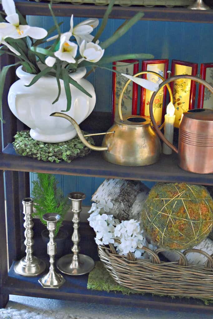 Vintage metal accents decorate a bookshelf for Spring.