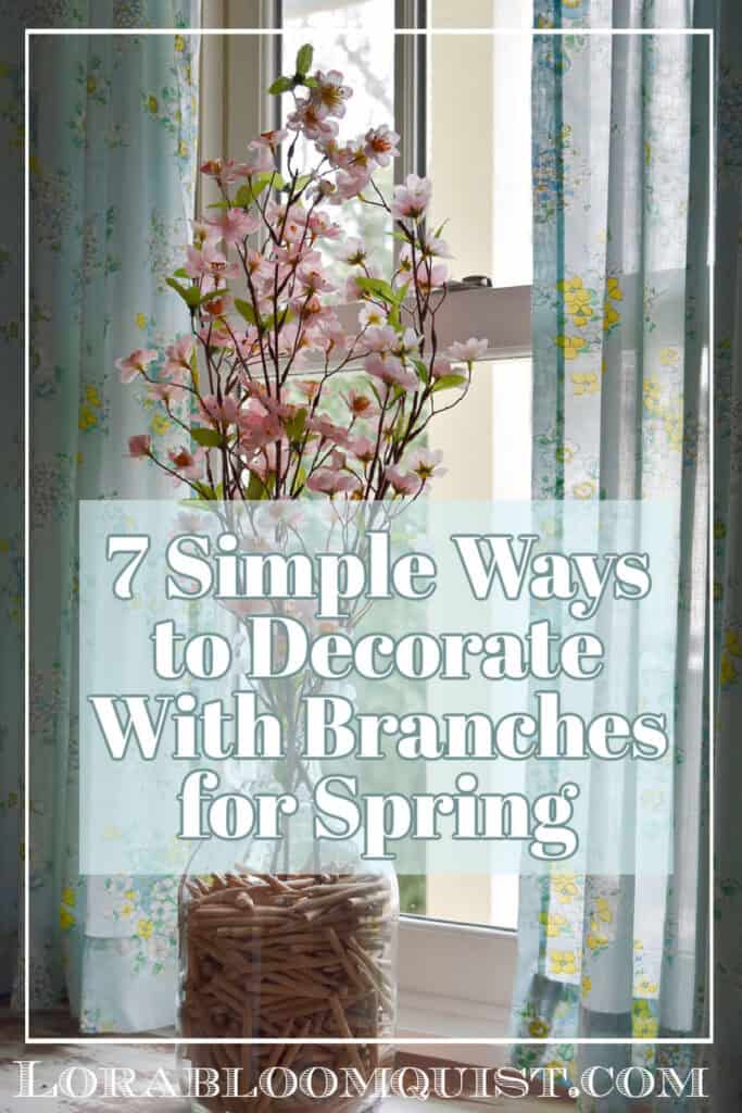 Faux pink apple blossoms fill a glass jug as Spring decor.
