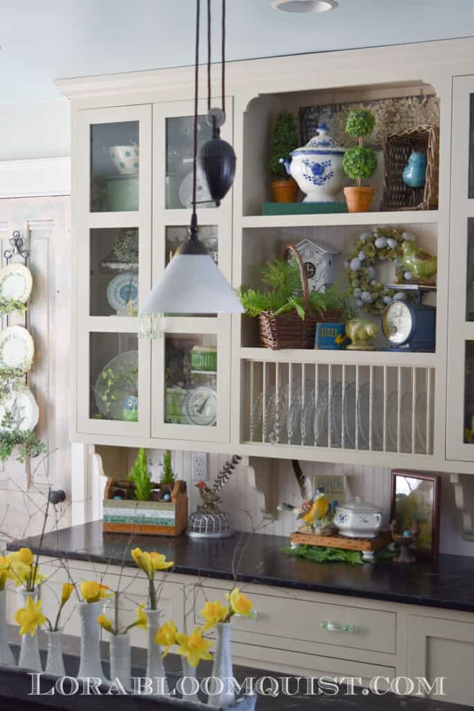 Farmhouse kitchen glass shelves decorated for Spring