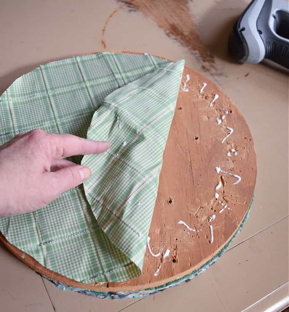Gluing fabric on old footstool.