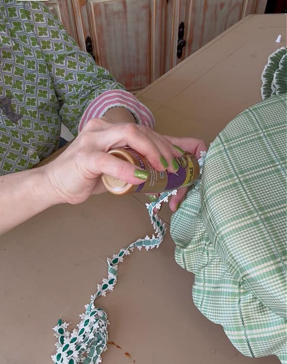 Gluing trim on old footstool for makeover.