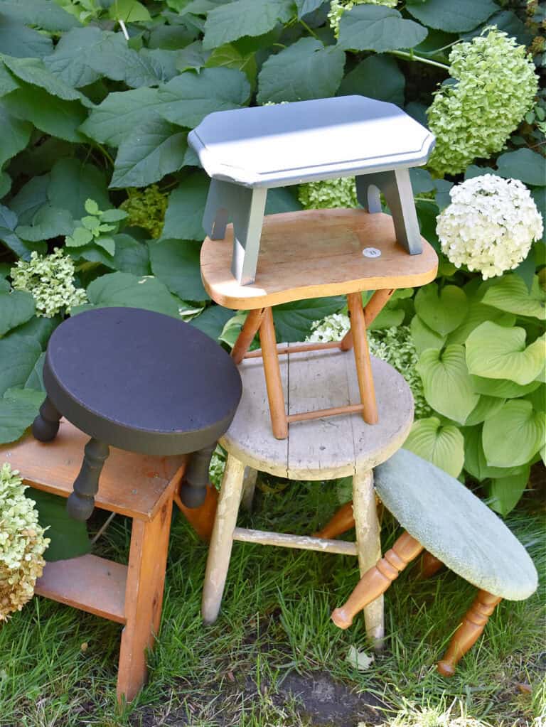 Variety of old wooden stools, stacked.