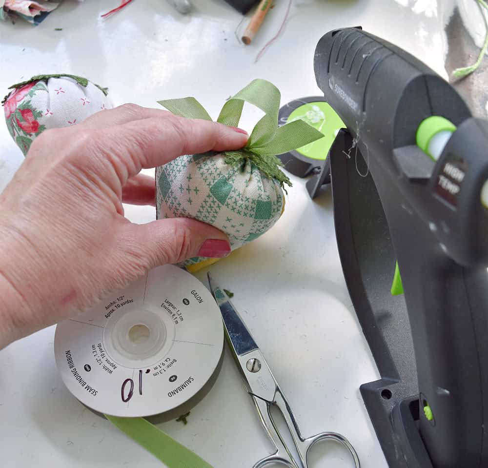 Crafting fabric strawberries with hot melt glue gun.