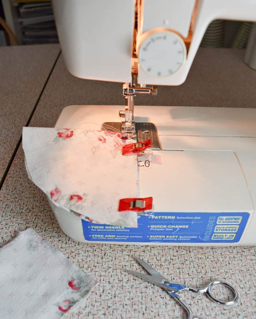 Sewing fabric to make strawberries.