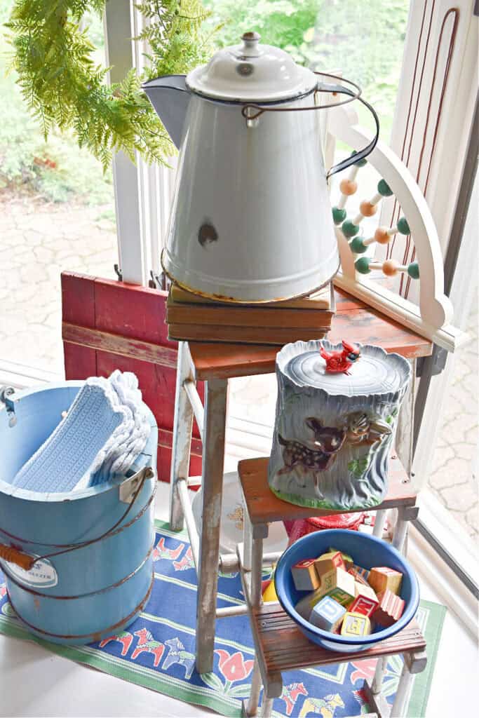 Enamelware coffee pot on old ladder and blue wood bucket.