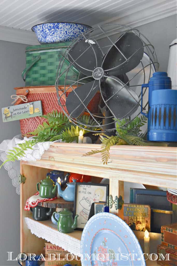 Vintage black fan and picnic baskets as summer hutch display.