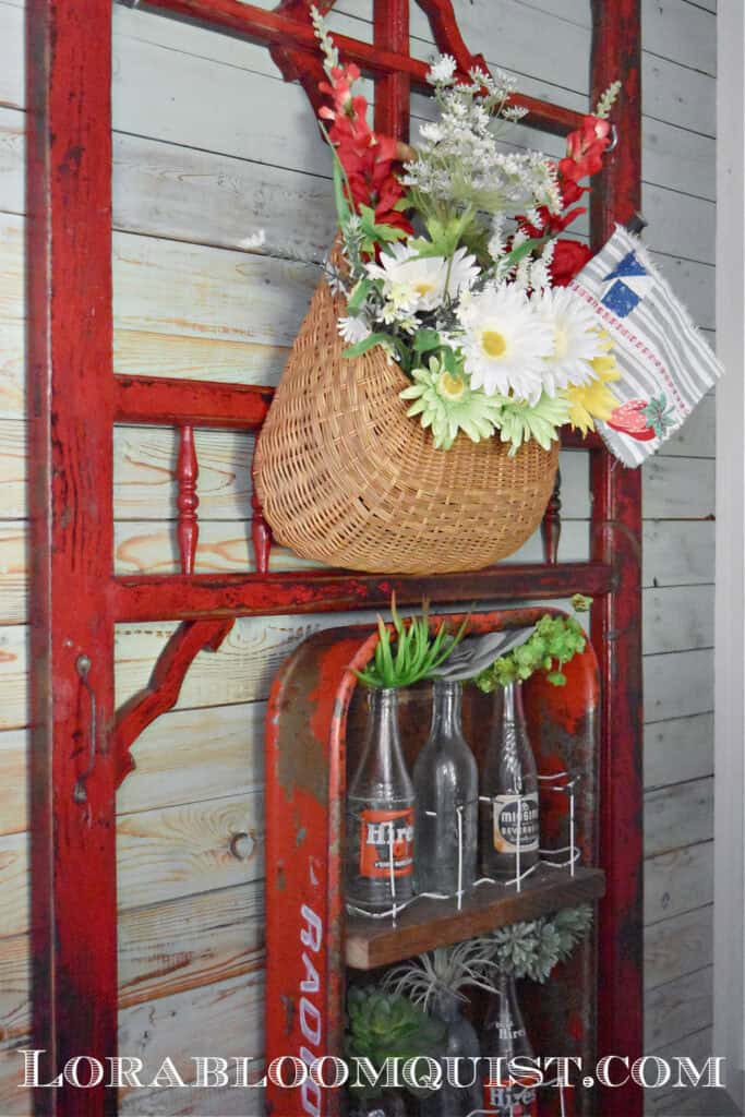 Basket of flowers hanging on antique screen door.