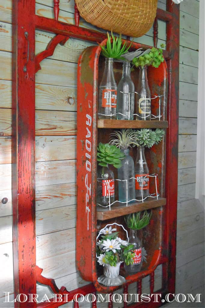 Old wagon upcycled as shelf and vintage pop bottles.