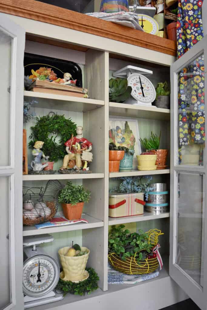 Colorful vintage finds in kitchen cupboard display.