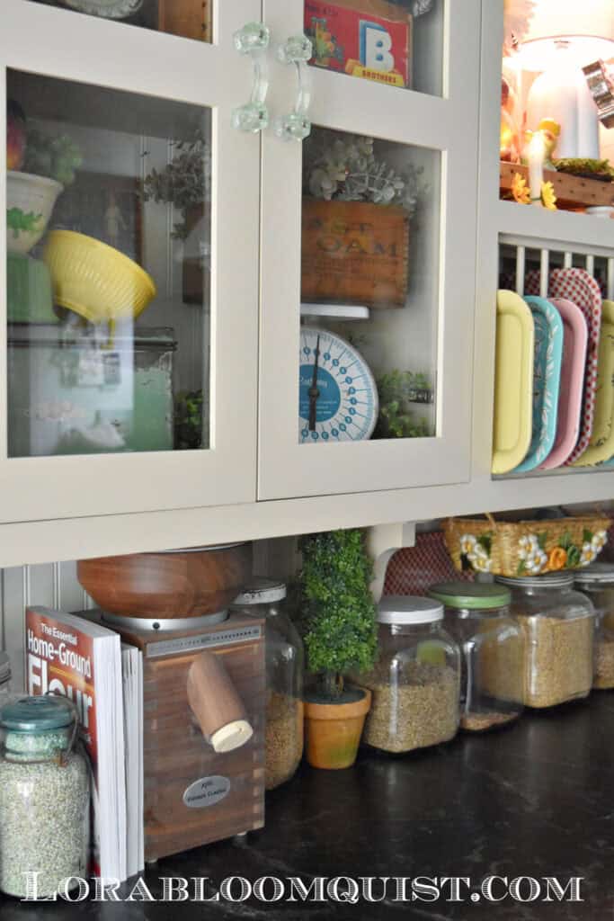 Grain mill and grains in glass jars in nostalgic kitchen.