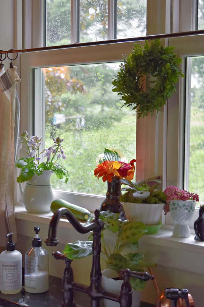 Kitchen windowsill with plants and flowers.