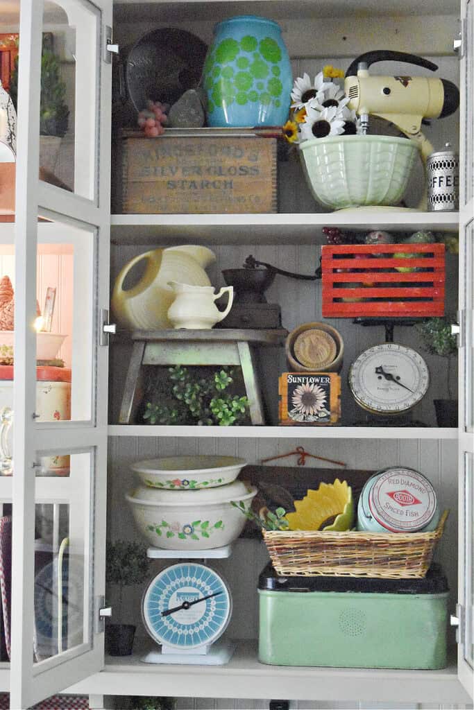 Vintage kitchen finds decorated in kitchen cupboard.