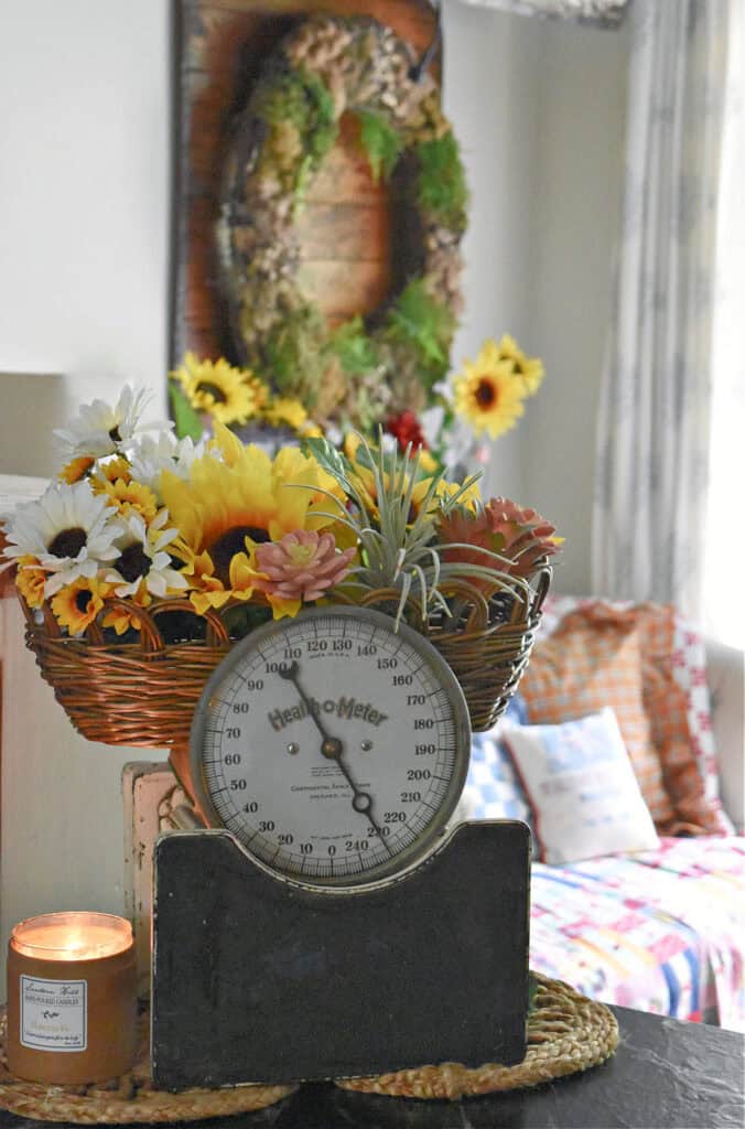 Vintage metal floor scale with basket of sunflowers.