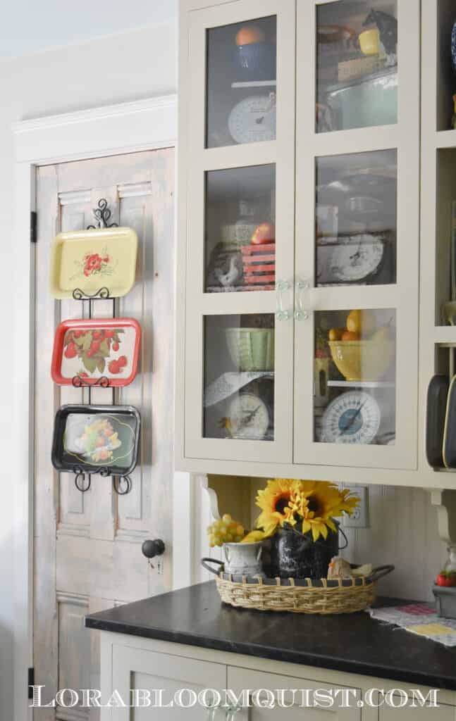 Glass front kitchen cupboards displayed with vintage decor collections.