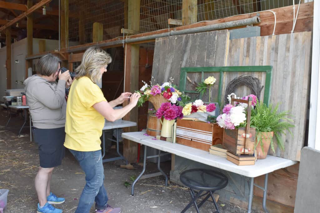 Ladies taking pictures of peony flower display.