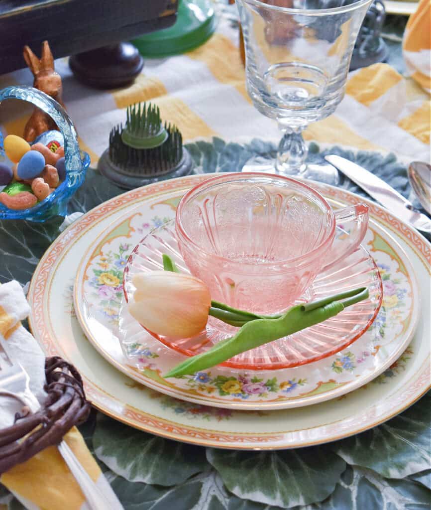 Pink depression ware cup and saucer on vintage plates.