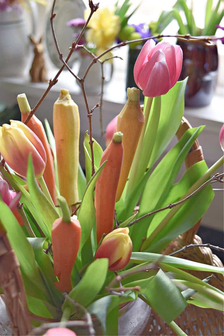 Tulips and fresh carrots in floral centerpiece.