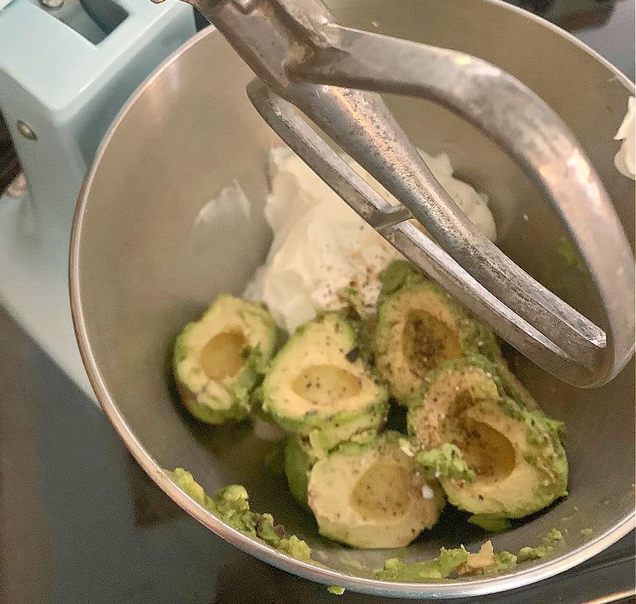Mixing avocados and cream cheese for dip.