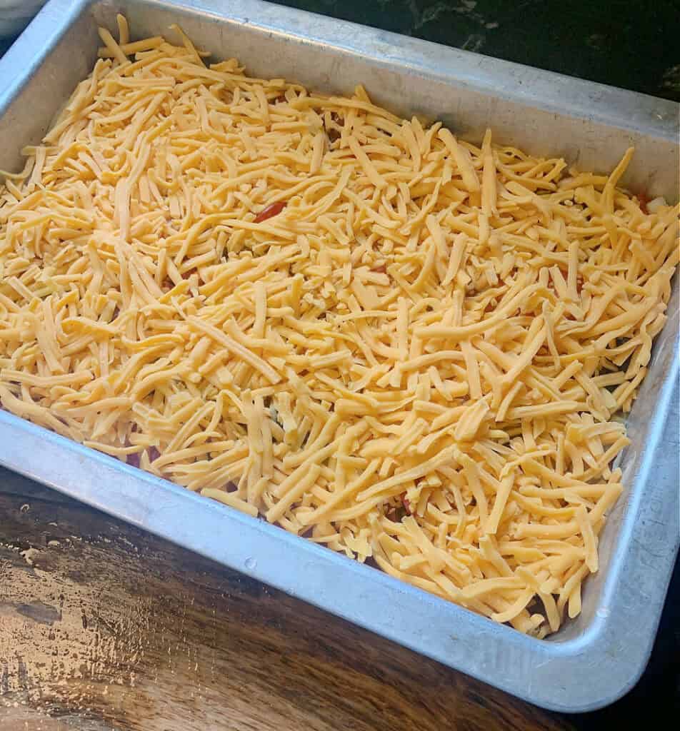 Shredded cheese on layered taco dip.