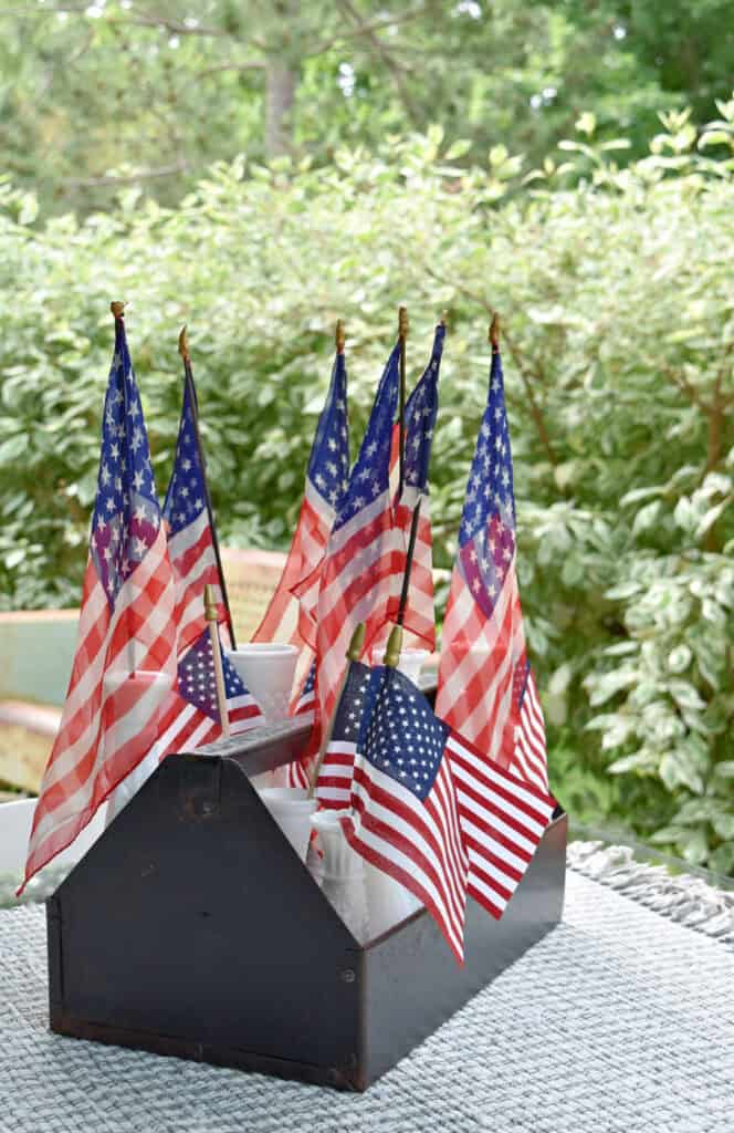 Metal tool caddy with flags in milk glass.