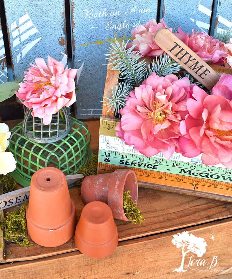 Peonies with garden decor in tool caddy.