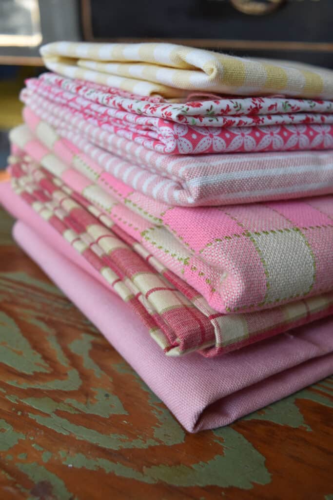 Pink cottage style fabrics stacked.