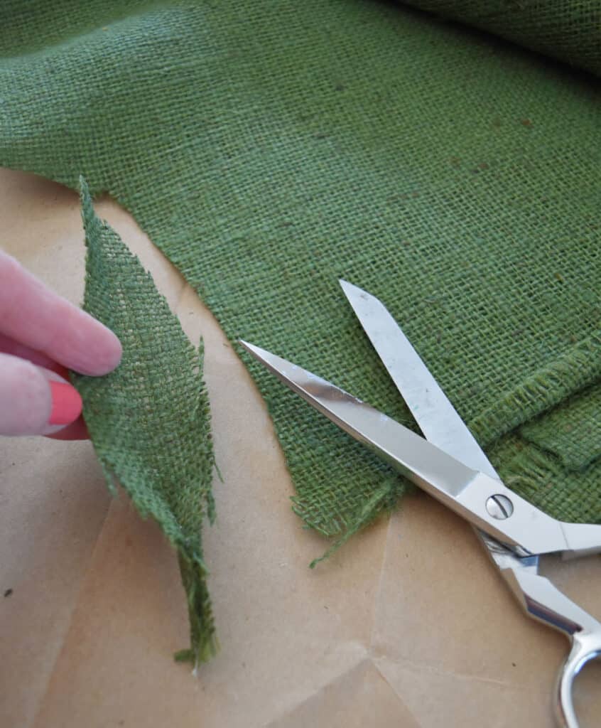 Cutting green burlap.