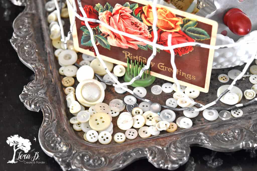 Vintage buttons scattered around a Valentine cloche display