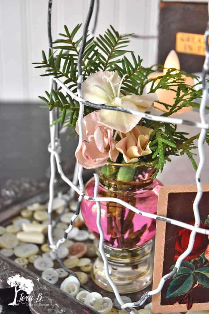 Small vase of flowers underneach a repurposed fencing cloche