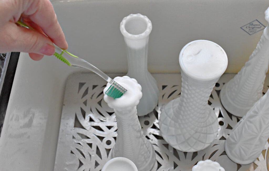 Cleaning narrow neck vases with toothbrush.