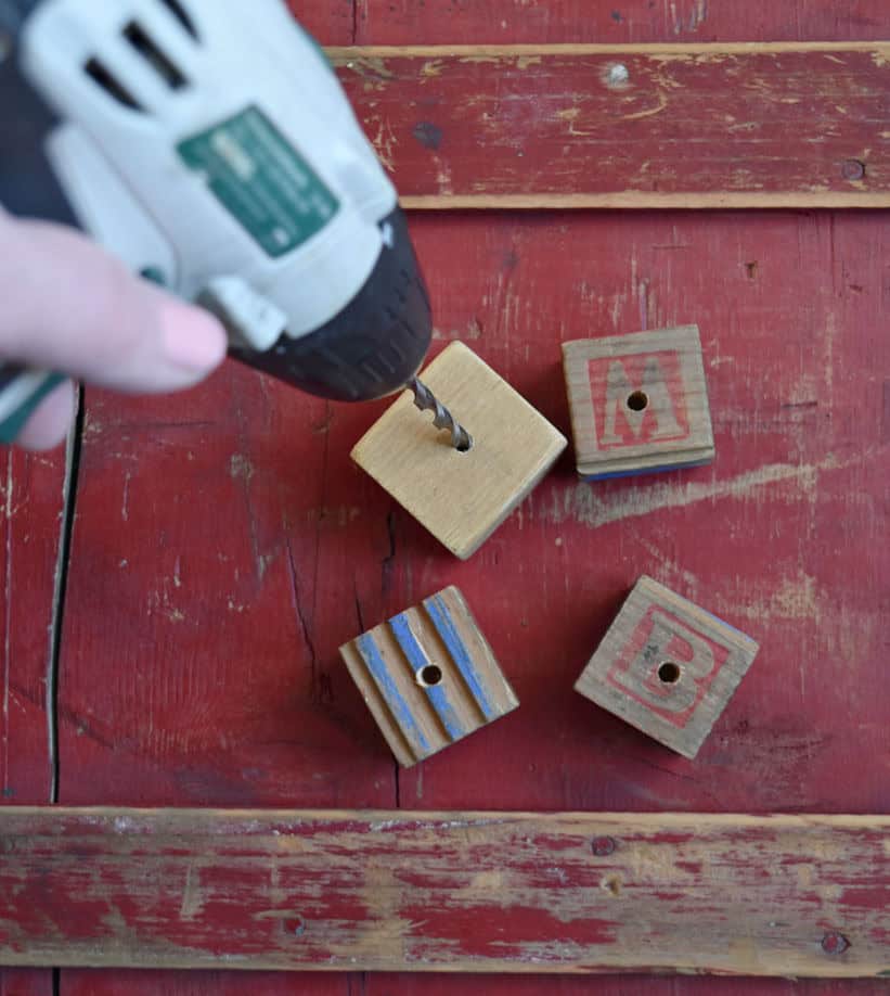 Drilling holes in wooden alphabet blocks.