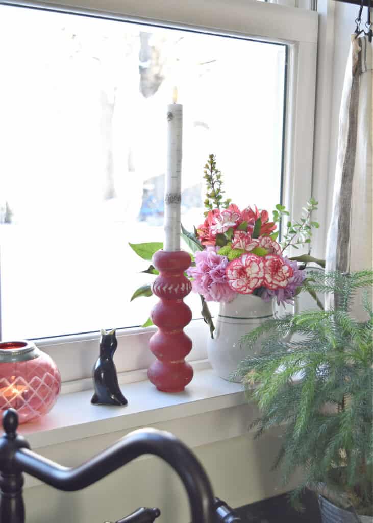 Fresh flowers and red candlestick as Valentine decor.