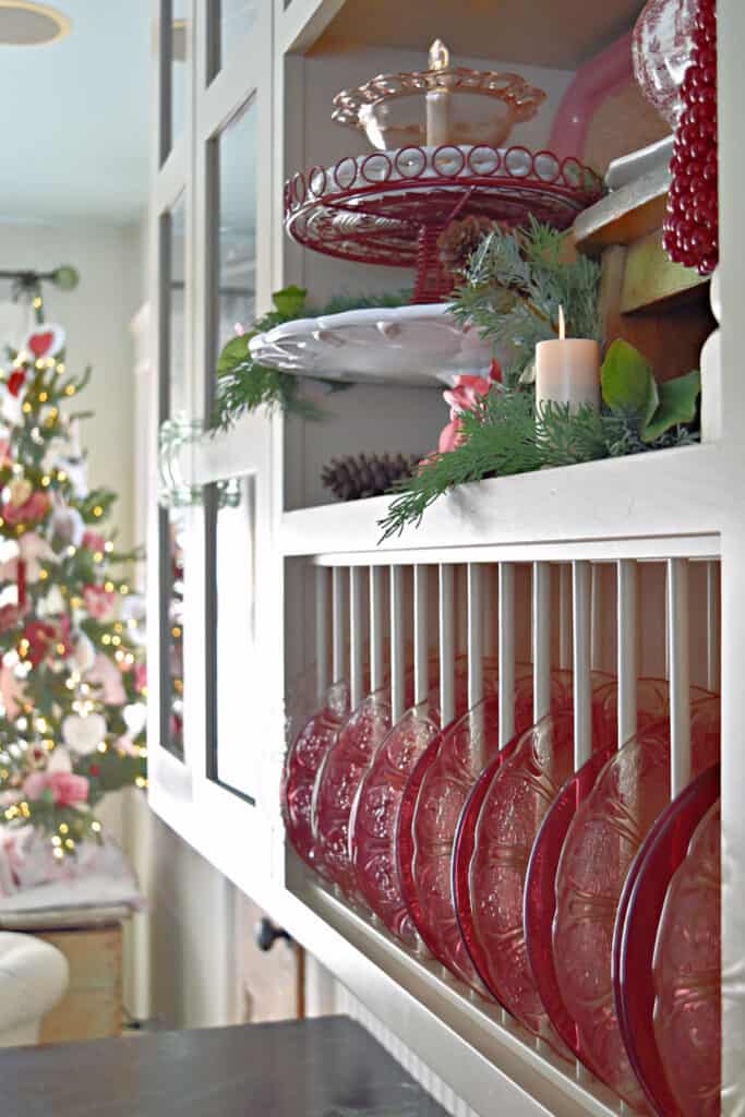 Vintage pink and red glass plates in plate rack as Valentines decor.