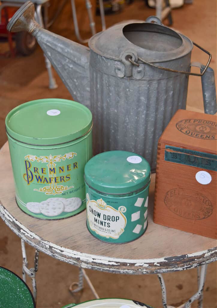 Vintage green treat tins, galvanized watering can and wooden cigar box.