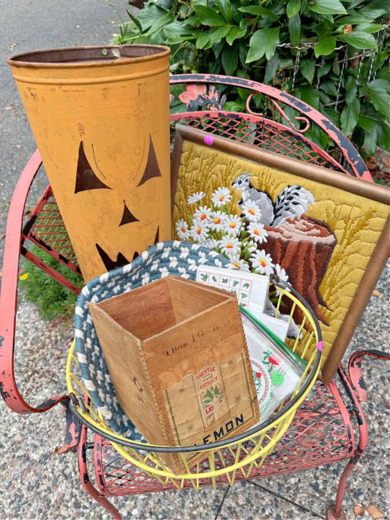 Jack o Lantern metal bucket, needlepoint framed art, yellow egg basket and vintage napkins and box.