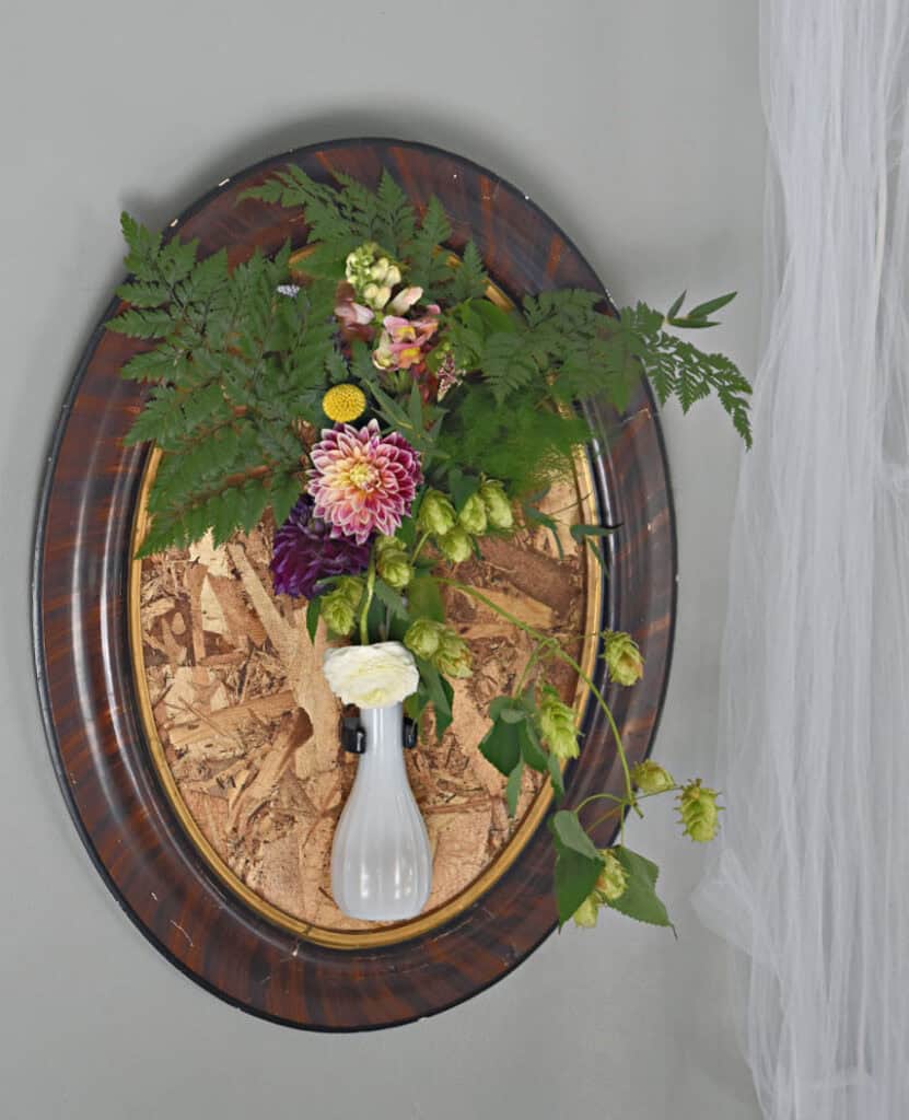 Vintage frame with flowers in vase as wedding decor.