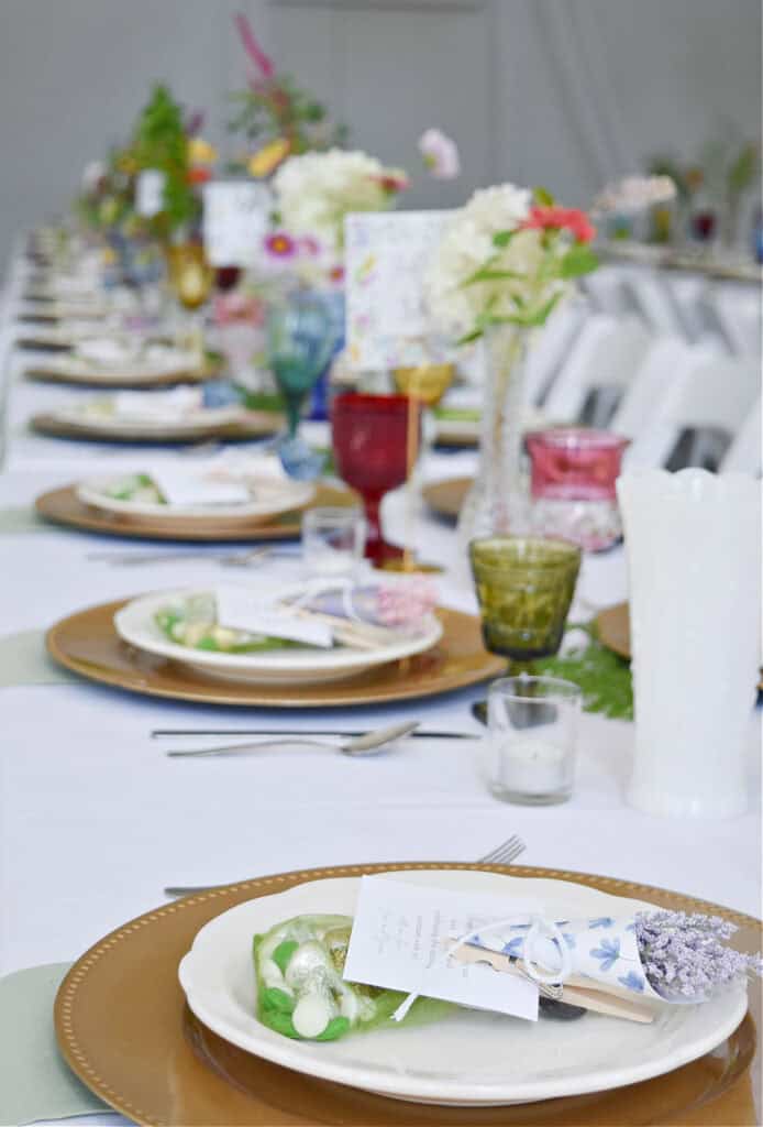 Garden party themed wedding reception decor with colorful glass goblets.