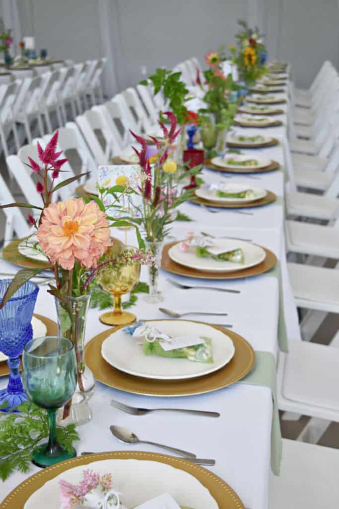 Garden party themed wedding reception decor on long table.